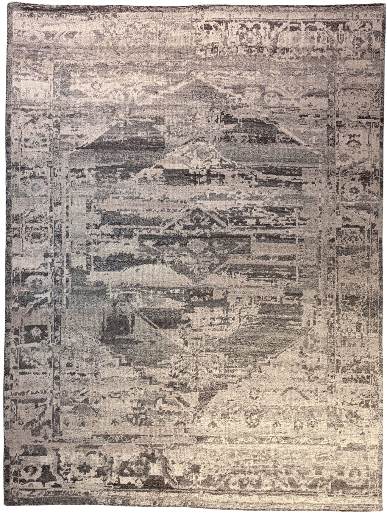 A distressed vintage-style area rug featuring an abstract, collage-like pattern in muted beige, gray, and charcoal tones.