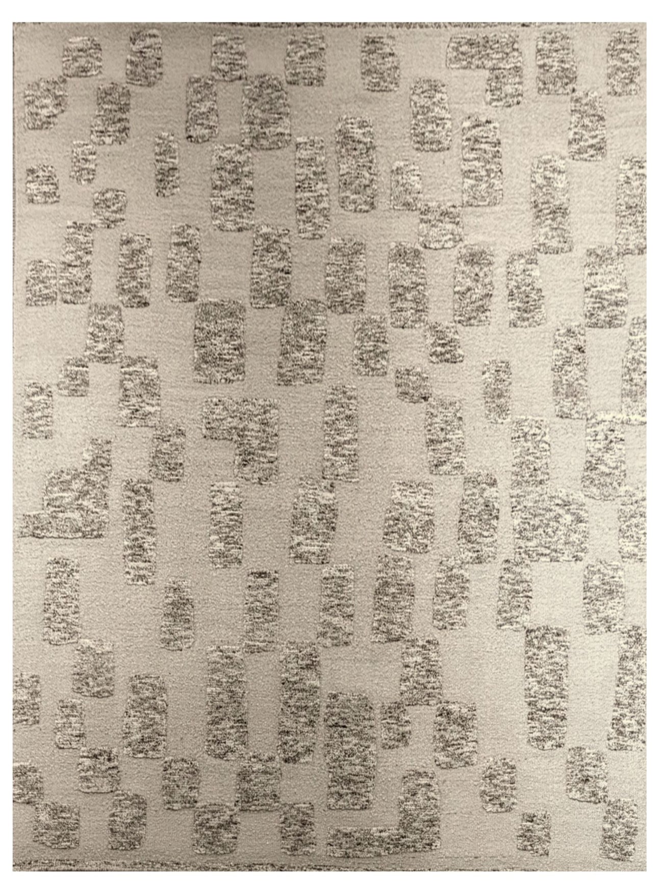 An area rug with a textured abstract pattern of vertical rectangular blocks in taupe and grey on a warm beige background.